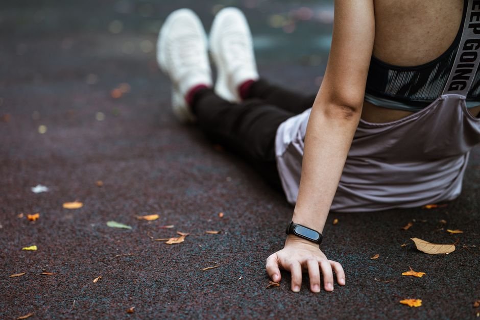 A runner resting with hands on knees after finishing a run outdoors