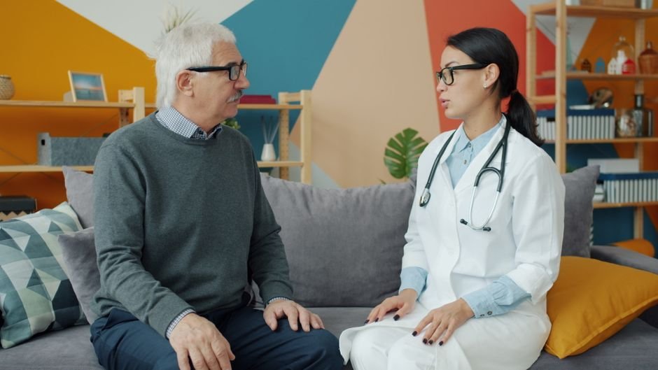 An older man in conversation with a clinician in a consulting room
