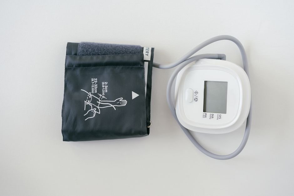 A blood pressure cuff and digital monitor resting on a table