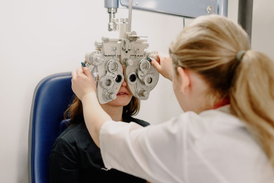 A clinician examining a patient’s eye with an ophthalmic instrument