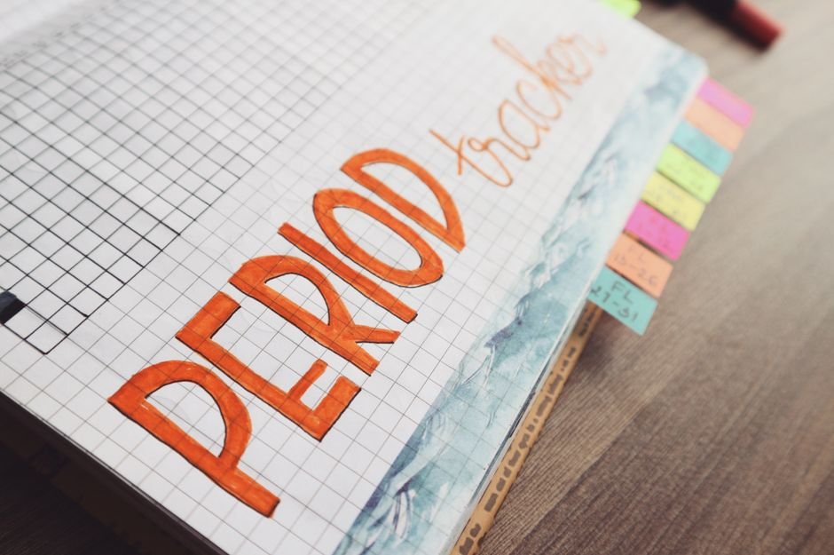 A pocket calendar and pen on a desk with dates circled