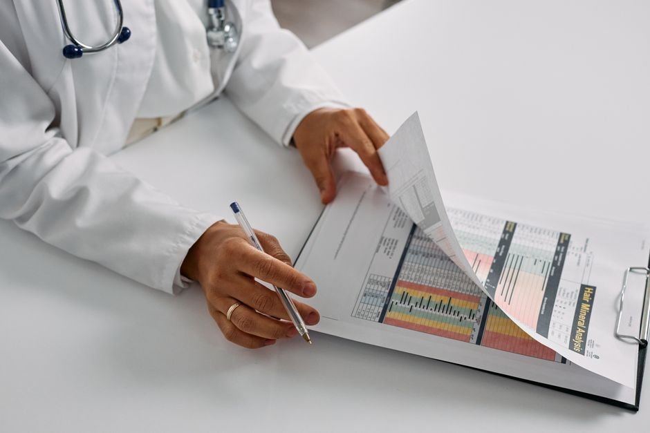 A clinician reading through a folder of medical records at a desk
