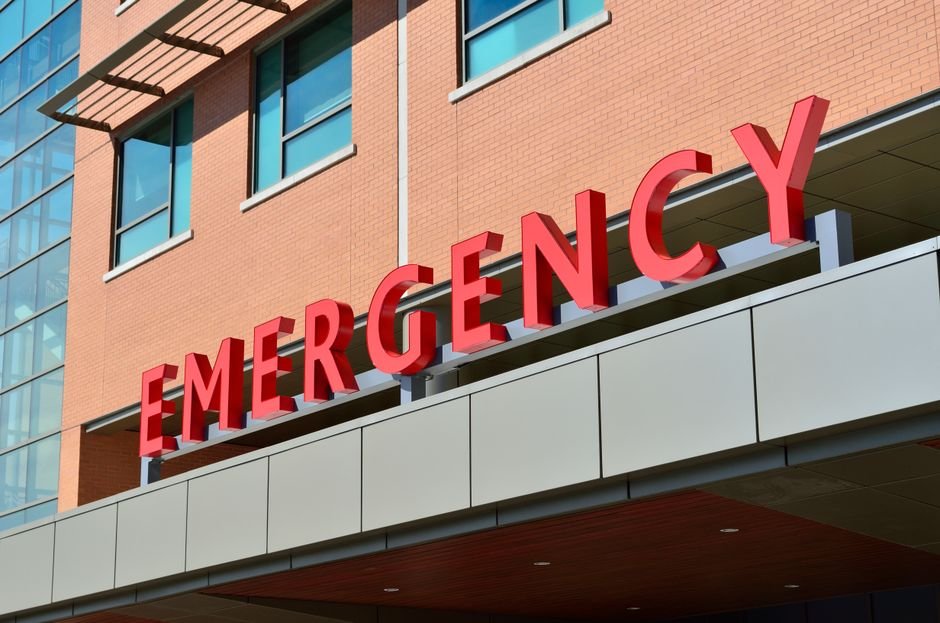 The illuminated entrance sign of a hospital emergency department at night